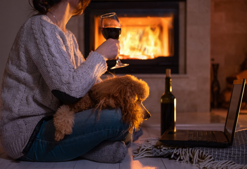 Hund hygger med sin ejer ved brændeovnen Hund hygger med sin ejer ved brændeovnen